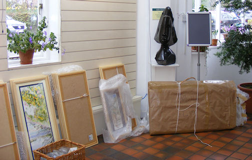 Paintings, wrapped in protective bubble plastic, waiting to take their places on the gallery walls